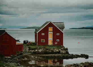 Ett rött hus som ligger precis vid havet