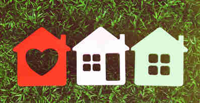 Tre olika ikoner föreställande hus ligger på en gräsmatta