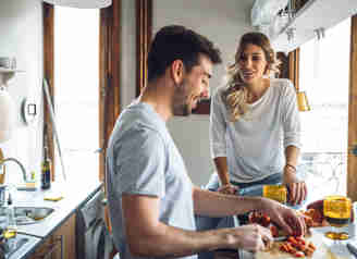 En man och en kvinna lagar mat i ett kök