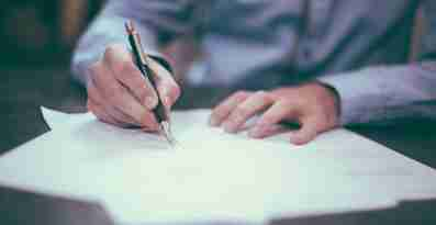 En person skriver på ett avtal