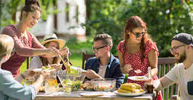 En grupp vänner som äter middag utomhus